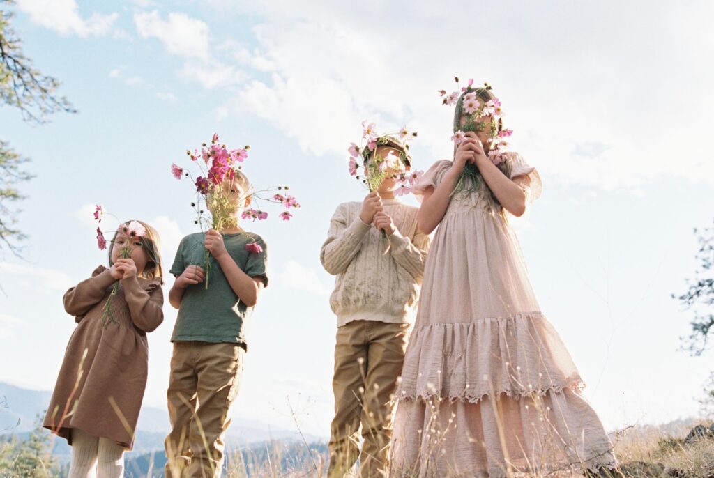 children with flowers shot on Kodak Portra 400 film with fluffy clouds